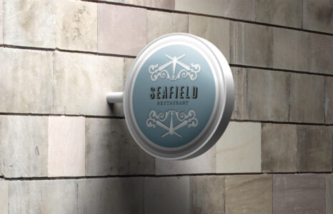 Seafield Restaurant round wooden sign on stone wall